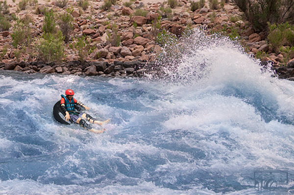 Background of same photo of male white-water rafter transformed to show white-water rafter now rafting down a chaotic, dangerous looking, turbulent river.