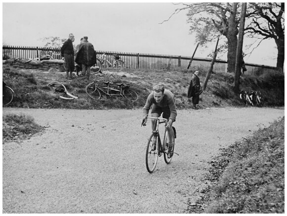 Original B&W photo, male cyclist riding a bike.