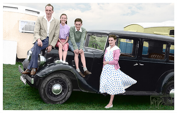 Photo of the family sitting on the hood of a vintage car now colorized.