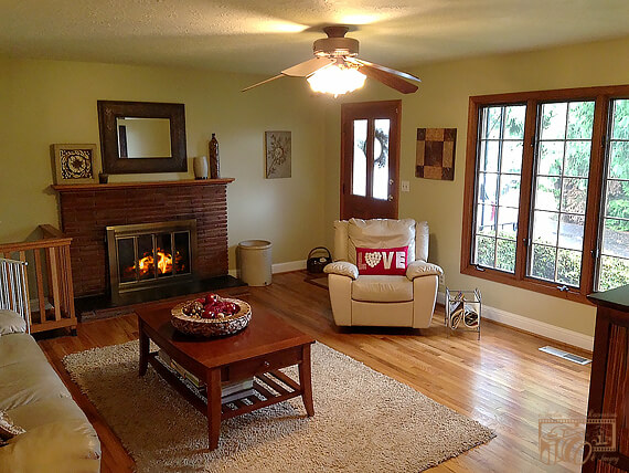 Image of the sitting room with a fireplace – now a cozy fire added to the fireplace.